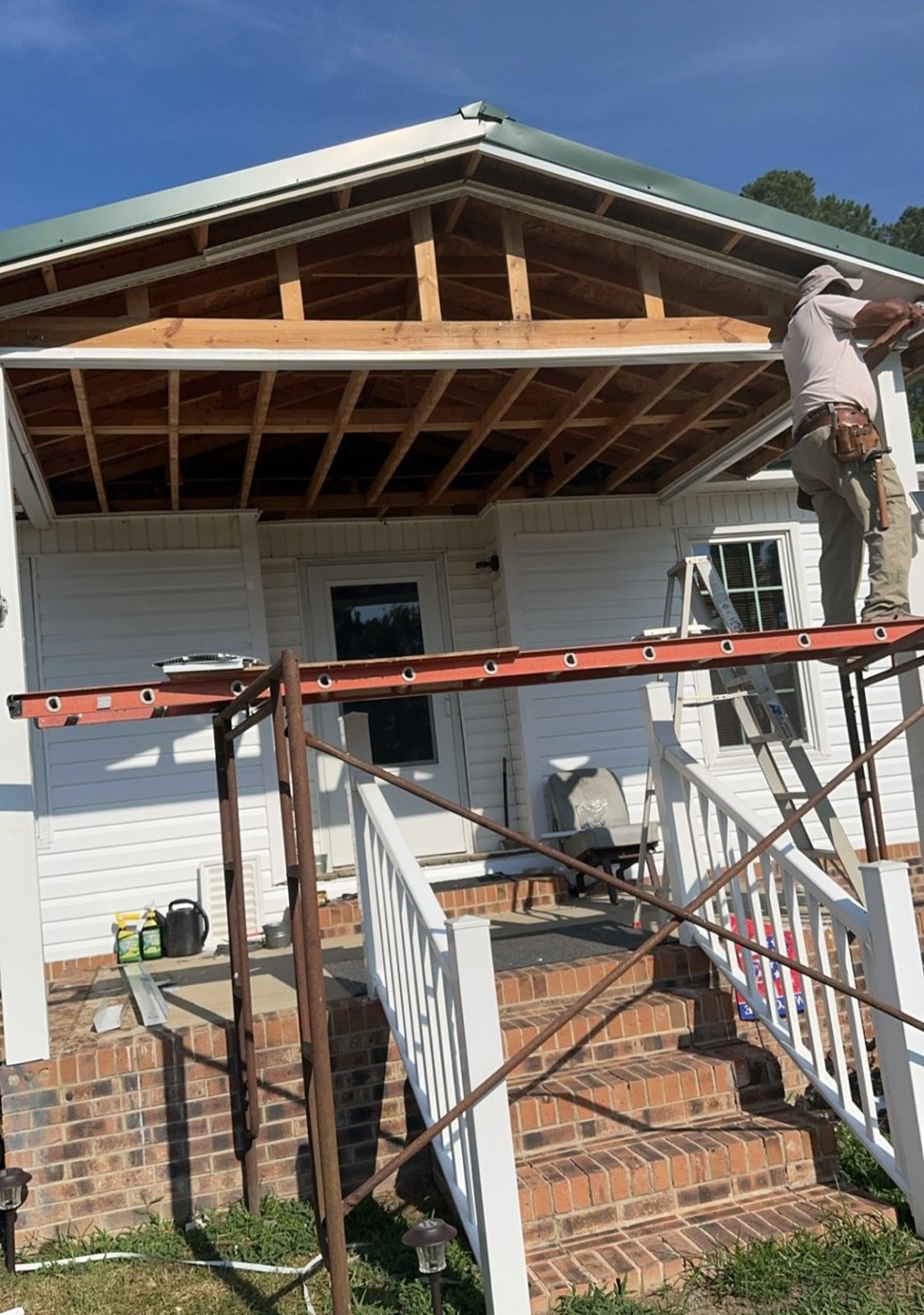 Porch finishing in progress, with framing and soffit details visible.